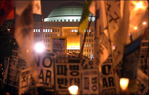 24일 저녁 국회앞에서 500여명의 시민들이 '미국의 이라크 침략전쟁 한국군 파병'을 반대하는 촛불시위를 벌이고 있다. 